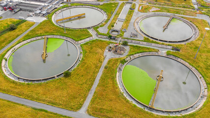 Wall Mural - Aerial view of the tanks of a sewage and water treatment plant enabling the discharge and re-use of waste water. It's a sustainable water recycling with treatment plant.