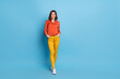 canvas print picture Full length body size view of attractive cheerful girl walking holding hands in pockets isolated over bright blue color background
