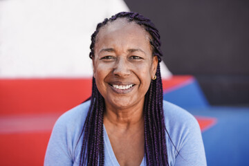 Happy african senior woman smiling on camera with colorful background