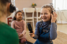 Little Girls With Headphones And Microphone Taking An Interview, Having Fun And Playing At Home.