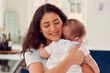© Monkey Business - Loving Mother Caring For Baby Son At Home In Kitchen Together
