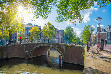 Sticker - Famous romantic Amsterdam - beautiful sunny day on the old street of Amsterdam. Narrow canal, old bridge and traditional houses. Sunlight. Amsterdam, Holland, Netherlands, Europe.