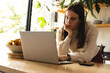 © Wavebreak Media - Thoughtful non-binary trans woman using laptop in the kitchen at home