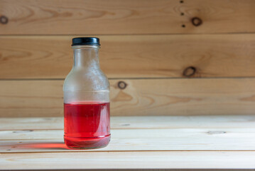 Half red liquid on wooden background