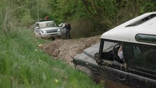 Old All-terrain Truck Is Pulled Out Of Mud By SUV With A Winch