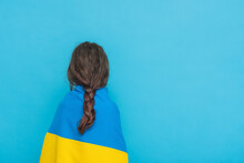 Yellow With Blue Fabric On The Shoulders. Photo Of A Girl With A Braid On A Blue Background.