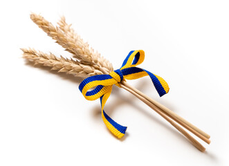 Wall Mural - Bundle of wheat spikes with yellow and blue ribbon in colors of Ukrainian flag isolated on white. Concept of food supply crisis and global food scarcity because of war in Ukraine