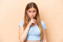 Young Caucasian Woman Isolated On Beige Background Showing A Sign Of Silence Gesture Putting Finger In Mouth