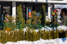 Beautiful Snowy Terrace In Winter With Bird House, Plants And Snowman