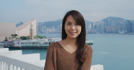 Poster - Woman smile to camera with the background of Hong Kong city