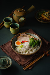 Wall Mural - Asian noodle soup on table, ramen with pork, vegetables and egg in a bowl. Copy space