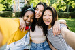 © Xavier Lorenzo - Three multiracial best women friends taking selfie portrait together outdoors - Female friendship concept with happy diverse teenager girls having fun in city street