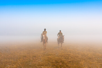 KOLKATA, WEST BENGAL, INDIA - HANUARY 21ST 2018 : Two mounted police coming out of on their horses, in a foggy winter morning.