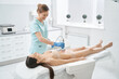 © Svitlana - Happy woman beautician carrying out radiofrequency lifting of stomach