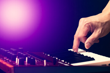 Wall Mural - male musician hand playing on synthesizer keyboard. music background