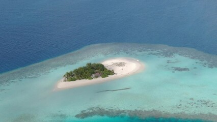 Wall Mural - aerial camera flying around small maldivian island among blue ocean water