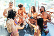 © Davide Angelini - Multiracial friends drinking champagne together on pool party - Diverse young people having fun at a holiday resort