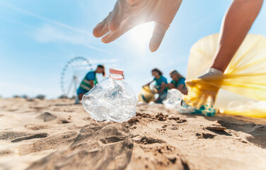 Group of eco volunteers picking up plastic trash on the beach - Activist people collecting garbage protecting the planet - Ocean pollution, environmental conservation and ecology concept	
