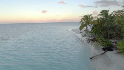 Wall Mural - maldivian island in indian ocean, camera moving along beach with palms and sand to open sea with sun