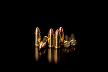 Pistol Cartridges 9 Mm On A Smooth Glossy Surface With Reflections. Ammunition For Pistols And PCC Carbines On A Dark Back.