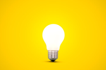 glowing light bulb isolated on a bright yellow background.