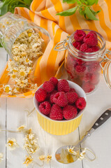 Wall Mural - Raspberries in a bowl and a berry on the table