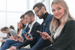 © ASDF - group of young business people looking at their smartphone screens.