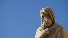Marble Statue Of A Philosopher Seen From Below With Blue Sky. Conceptual, Descriptive Image
