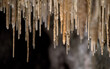 Close up of soda straw formations in underground cave where ground water leaves small deposits of calcite forming a hollow tube over millions of years.