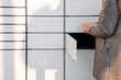 © Maksym - Post locker. Delivery automat terminal and hands with parcel courier box. Parcel delivery, pickup point with lockers, hand with parcel, contactless pack delivery.