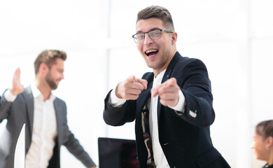 Wall Mural - cheerful business man standing in the office and pointing at you.