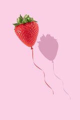 Wall Mural - Strawberry balloon on bright pink background. Minimal summer fun concept