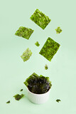 Fototapeta  - Flying crispy nori seaweed. Healthy snack. Traditional Japanese dry seaweed sheets. Creative concept, levitation.