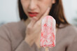 Asian Woman touching her chin feeling sensitive teeth when eating an ice cream. Have a gum and oral problem.