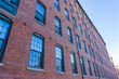 The fasade of a historic cotton factory building in an old industrial park on the Nashua River in May. Nashua, New Hampshire, USA