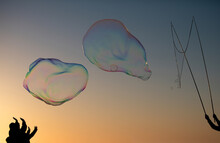 Big Soap Bubbles In Sunset. Giant Soap Bubble. Flying Soap Bubbles On Sky Blue Background At Sunset.