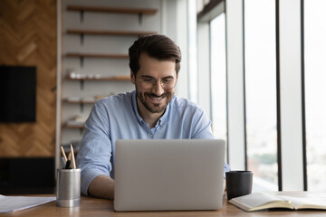 Wall Mural - happy business project manager working from home, using laptop, typing, making video call, looking a