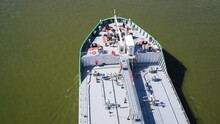Close-up Aerial View Of Grey Deck Of Large Oil Products Tanker Sailing On Green River Water In A Sunny Day. 4K Resolution Real Time Video. Shipping Theme.