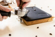 Barista presst Kaffeemehl in einen Siebträger zur Zubereitung eines Espresso.