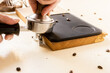Barista presst Kaffeemehl in einen Siebträger zur Zubereitung eines Espresso.