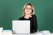 © Volodymyr - Portrait of teacher or female tutor working at table in school. Young women student studying in class.