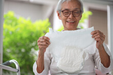 Happy Smiling Asian Senior Woman Showing Disposable Diaper For Adult,looking At Nappy Pamper With Satisfaction,old Elderly Patient With Urinary Incontinence,consumer Goods,health Care Concept