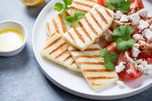 Slices Of Grilled Halloumi Cheese With Red Tomatoes, Feta Cheese And Parsley, Close-up, Studio Shot