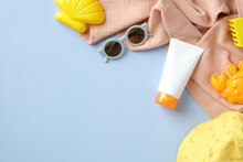 Flat Lay Sunscreen Tube Mockup For Kids And Babies, Sunglasses, Panama Hat, Towel, Sand Molds On Blue Background. Sun Safety, Infant Sun Protection Concept.