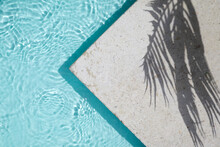 Swimming Pool Top View Background. Water Ring And Palm Shadow On Travertine Stone