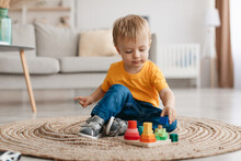 Early Development Concept. Little Toddler Boy Playing With Educational Wooden Toy At Home, Sitting In Living Room
