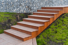 Wooden Staircase Assembled From Boards, Landscape Design In A Private House, Brown Staircase, Descent Up The Steps, Green Grass Lawn.
