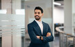 © Prostock-studio - Cheerful confident handsome millennial muslim businessman with beard in suit with crossed arms