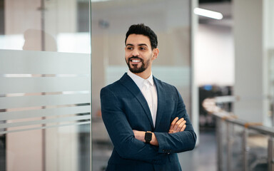 Wall Mural - Cheerful confident handsome millennial muslim businessman with beard in suit with crossed arms