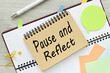 pause and reflect . planner page and notepad on desktop. text on the page. colorful stickers